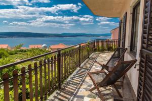 a balcony with two chairs and a view of the water at Apartments Faro & Mondo in Crikvenica