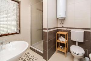 a bathroom with a tub and a toilet and a sink at Apartments Faro & Mondo in Crikvenica