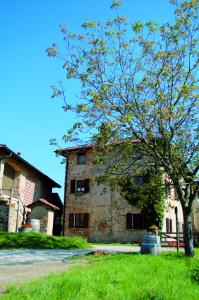 an old stone building with a tree in front of it at Agriturismo La Costa - Casa Vacanze in Perego