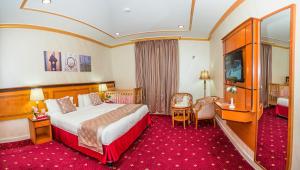 una camera d'albergo con un letto e una televisione di Amjad Al Deafah Hotel a La Mecca