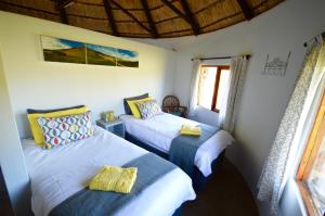 a bedroom with two beds and a window at Swartkop Cottage in Winterton