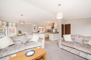 a living room with two couches and a table at Thistle Lodge in Auchterarder