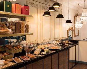 a kitchen filled with lots of plates of food at Hotel Malte - Astotel in Paris