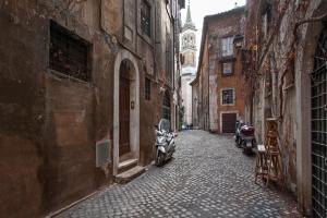 an alley with two motorcycles parked on a cobblestone street at Antique-Modern Flat by Navona Square in Rome