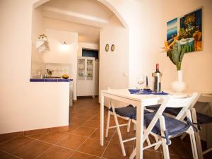 a kitchen and dining room with a white table and chairs at Appartamento gli archi a 100 metri dalla spiaggia in Castellammare del Golfo
