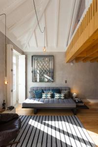 sala de estar con sofá azul y escalera en Gold & Grey Loft Almada, en Oporto