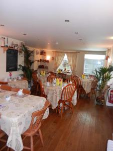 West Nattrass Guest House في ألستون: غرفة طعام مع طاولات وكراسي في مطعم