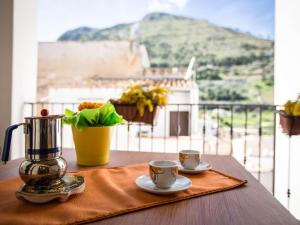 a table with two cups and a blender on a balcony at Appartamento gli archi a 100 metri dalla spiaggia in Castellammare del Golfo