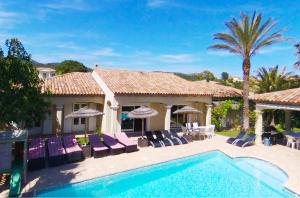 une villa avec une piscine et des palmiers dans l'établissement Luxueuse Villa Récente à Saint Raphaël de Plain Pied, à Saint-Raphaël