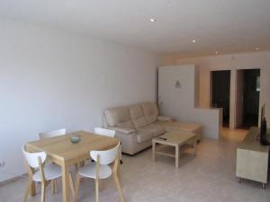 uma sala de estar com uma mesa e um sofá em Kaminias II Apartament per 4 persones a Politur em Platja d'Aro