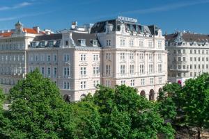 ein großes weißes Gebäude mit einem Schild darüber in der Unterkunft Hotel Regina in Wien