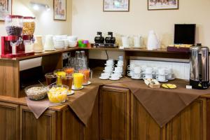 a kitchen with a counter with a bunch of food at Hotel Maksymilian in Krakow