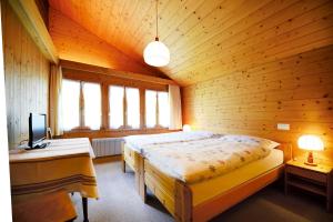 a bedroom with a large bed in a wooden room at Landgasthof Tännler in Innertkirchen