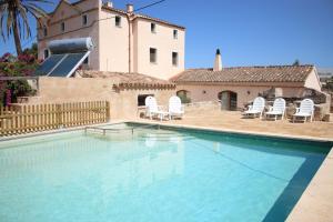 a swimming pool with chairs and a house at Finca Santa Maria Magdalena in Ciutadella