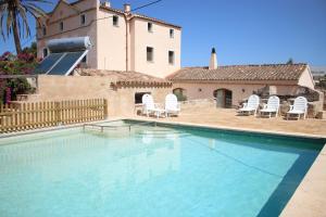 una piscina con sillas y una casa en Finca Santa Maria Magdalena, en Ciutadella