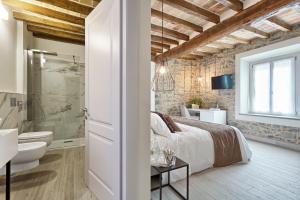 a bedroom with a bed and a bathroom at Relais Ginevra in Zocca