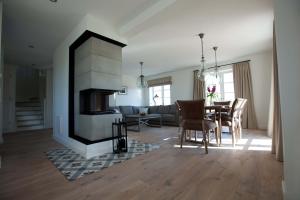 a living room and dining room with a fireplace at Tede Warft in Pellworm