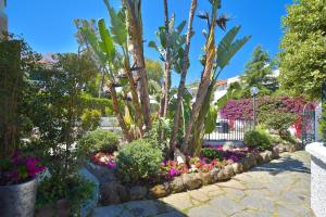 un jardín con flores y plantas en un patio en Villa Fortuna Holiday Resort en Isquia