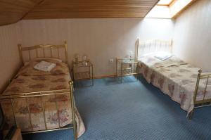 1 dormitorio con 2 camas y 2 mesitas de noche en Du Broliai Hotel, en Palanga