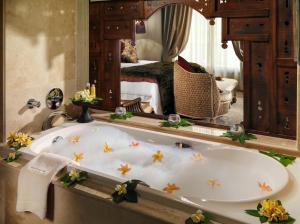 a bathroom with a bath tub in front of a mirror at Royal Garden Villas, Luxury Hotel in Adeje