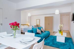 - un salon avec un canapé bleu et une table blanche dans l'établissement Stephanie Studios, à Larnaka