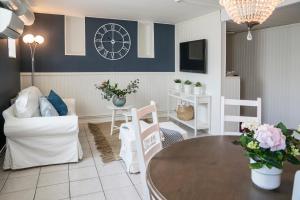 a living room with a table and a clock on the wall at Halmstad Hotell & Vandrarhem Kaptenshamn in Halmstad