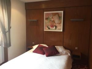 a bedroom with a bed with two red pillows on it at Résidence Les Cigogneaux in Ostheim