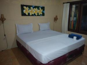 una camera con un grande letto bianco di Izzi Homestay a Gili Trawangan