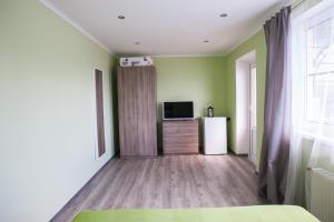 プリモルスコ・アフタルスクにあるHouse on Chernetskogoの緑の壁のベッドルーム(テレビ付)