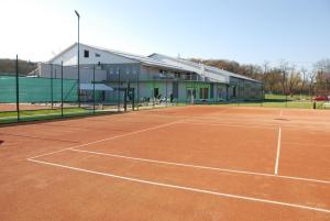 un campo da tennis di fronte a un edificio di Penzión Rocket Club a Lučenec