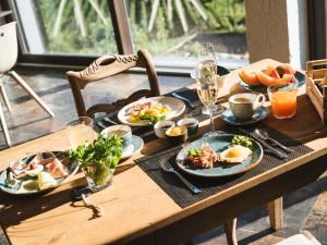 una mesa de madera cubierta con platos de comida y bebida en Garni Hotel Katzenthalerhof, en Lana