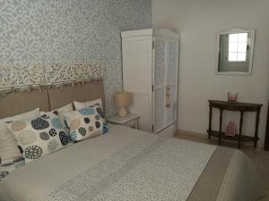 a bedroom with a bed with pillows and a refrigerator at Apartment Luz De Faro in Playa Honda
