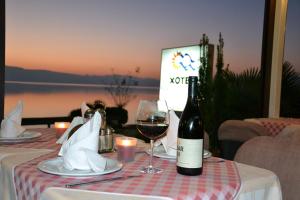 a table with a bottle of wine and a glass at Hotel Dva Bisera in Ohrid