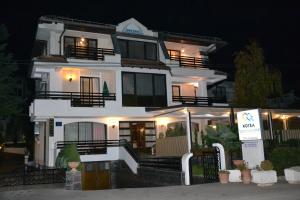 a white house with a sign in front of it at Hotel Dva Bisera in Ohrid