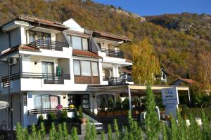 a large white building with a mountain in the background at Hotel Dva Bisera in Ohrid