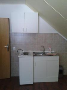 a kitchen with white cabinets and a sink at Dom Petra in Štúrovo
