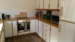 eine Küche mit weißen Schränken und einem Herd in der Unterkunft Lavendel Cottage in Sedgefield + 14 Fotos