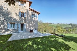 an external view of a stone house with a lawn at Relais Ginevra in Zocca