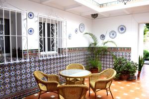 a patio with a table and chairs and plates on the wall at El Jardin BeNerja in Nerja