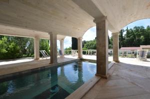 a swimming pool in a pavilion with a pool at Villa Le Querciolaie in Monteverdi Marittimo