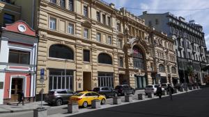 モスクワにあるホステル ワン クズニョツキー モストの建物前に停車する黄色い車