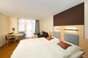 a bedroom with a large white bed and a table at Hotel Storck in Bad Laer