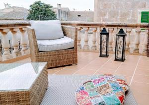 un patio con sillas de mimbre, mesa y linternas en Ermitans, en Petra