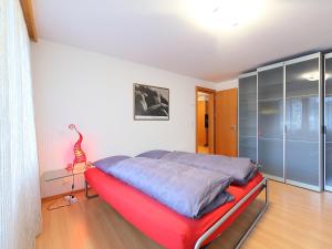a bedroom with a bed with a red bed frame at Brunnmatt Holiday Apartment Zermatt in Zermatt