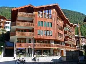 a large building with balconies on the side of it at Brunnmatt Holiday Apartment Zermatt in Zermatt