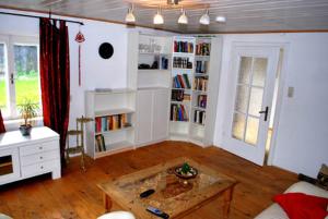 een woonkamer met een salontafel en boekenplanken bij Salzachblick in Oberndorf bei Salzburg