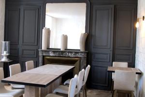 ein Esszimmer mit einem Tisch und einem Spiegel in der Unterkunft l'Escale de Broglie in Broglie
