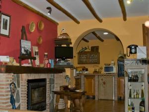 Elle comprend un salon doté d'une cheminée et d'un mur rouge. dans l'établissement El Rincon de Pepa, à La Zubia