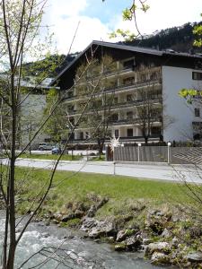 ein Gebäude an der Seite einer Straße neben einem Fluss in der Unterkunft Alpenappartements Domicil in Saalbach-Hinterglemm
