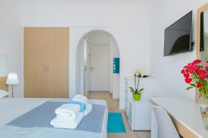 a hotel room with a bed, table and a mirror at Stephanie Studios in Larnaca